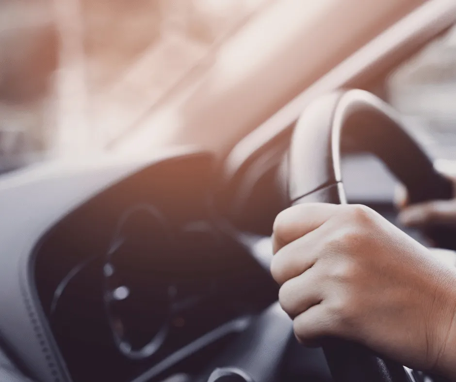 Des mains sur le volant d'un corbillard